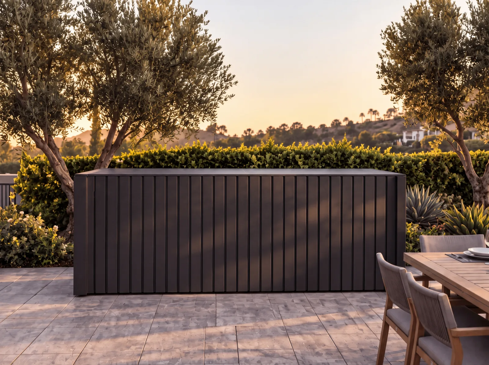Closed matte black POD 01 framed by olive trees on a landscaped terrace